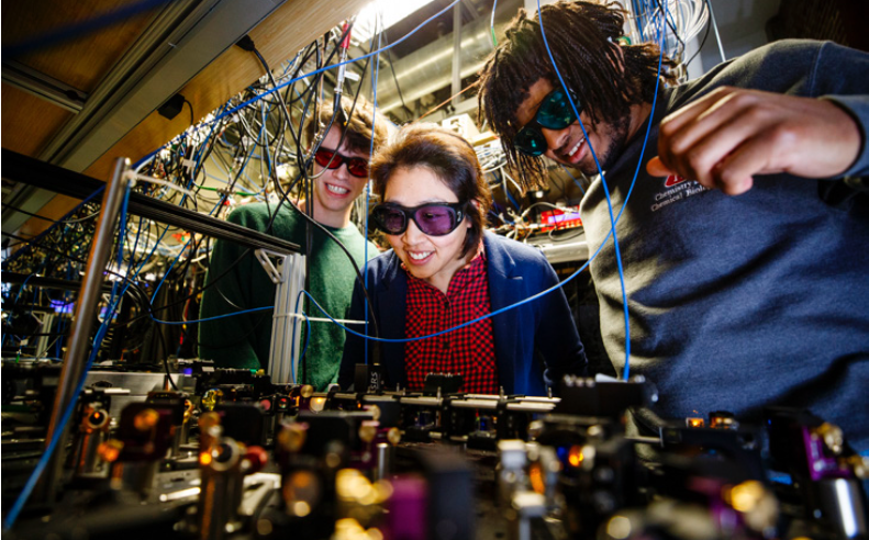 three people working with lasers